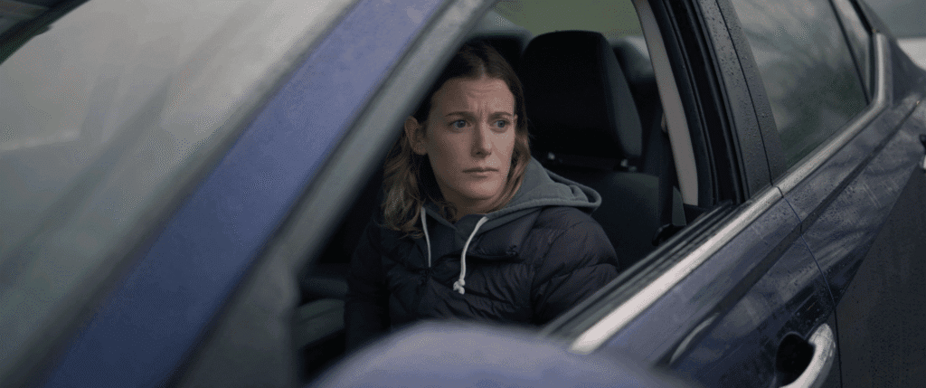 a young woman waits nervously in a car